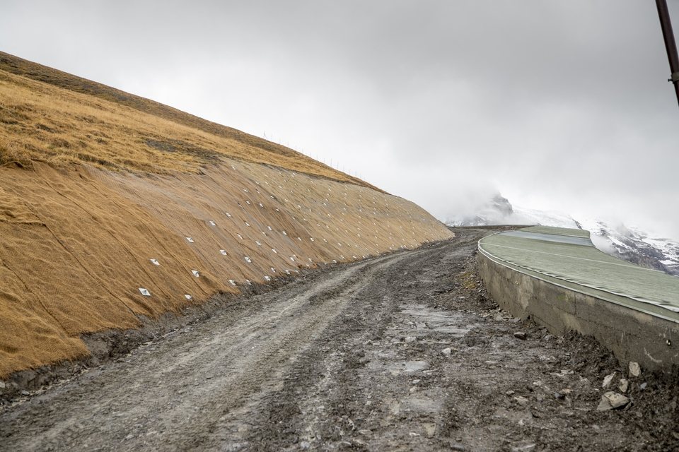 Jungfrau Railway Gallery and blue runway. The embankment is secured with jute nets and anchors. First comes the dung, then the net, which will be covered over in time.